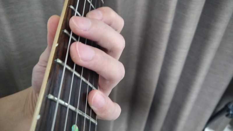 中指と薬指で低音弦側をに軽く触れてミュートし、高音弦側は人差し指と小指を寝かせて軽く触れてミュート