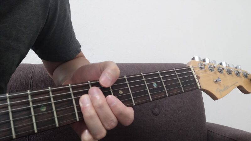 左手全体を前後させて弦を弾き分けようとしてしまうと、左手の形が崩れてしまう悪い例