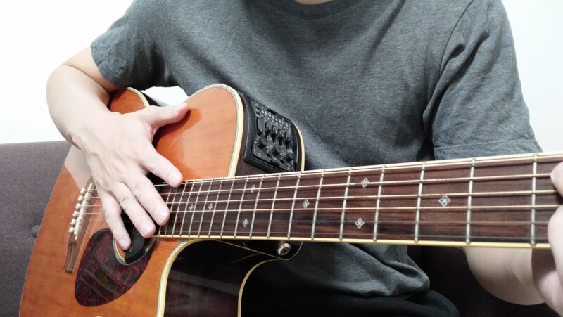 ギターからなるべく右手の指先を離すようにしておき、手首のスナップを効かせて指版の端あたりを目掛けて中指と薬指で素早く叩く