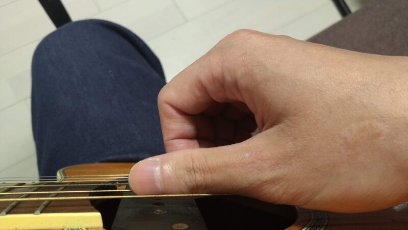 右手が摘まむ動作から開く動作に移る際に、右手の各指を各弦に置くようにサウンドホールの上から弦に右手全体を振り下ろす